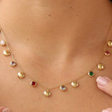 Gold necklace with colorful gemstones worn by a person