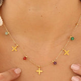 Necklace with colorful beads and gold 'X' charms on a person's neck